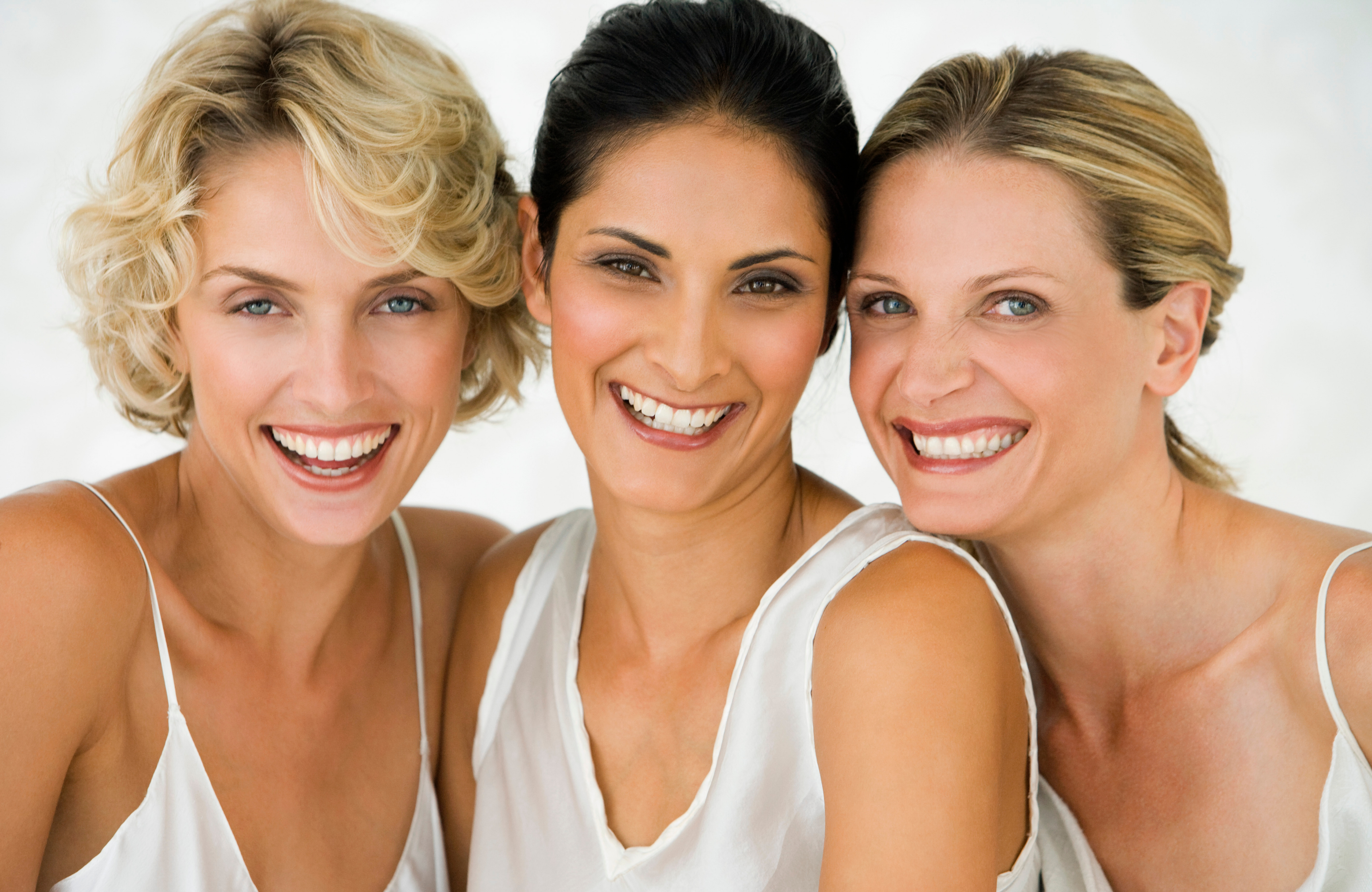 Trois femmes souriantes au teint éclatant illustrant la philosophie OYYO Lab : la beauté accessible à toutes, à tout âge, depuis sa salle de bain